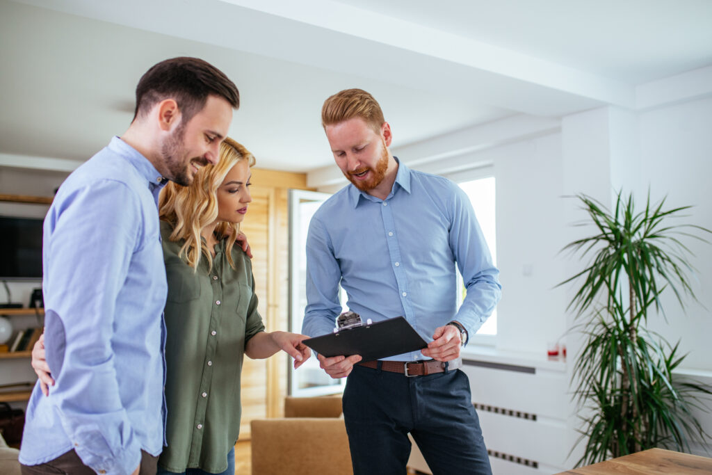 Property manager showing documents to a young couple.