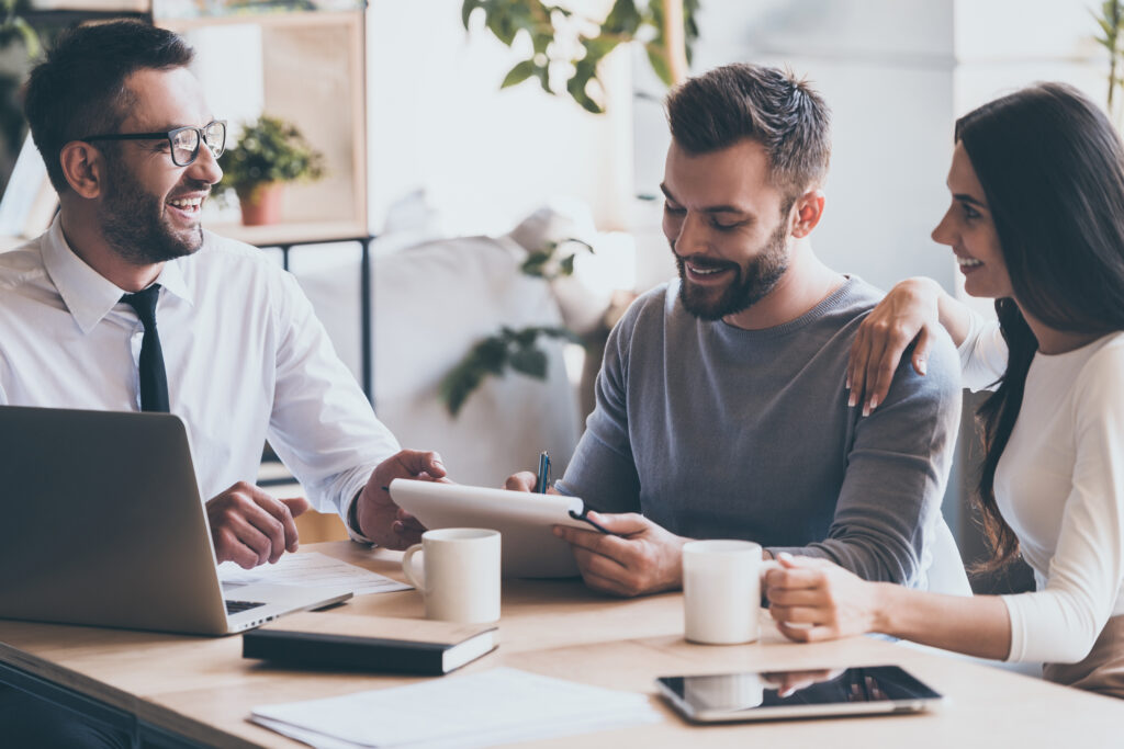 Real estate agent showing documents to young couple